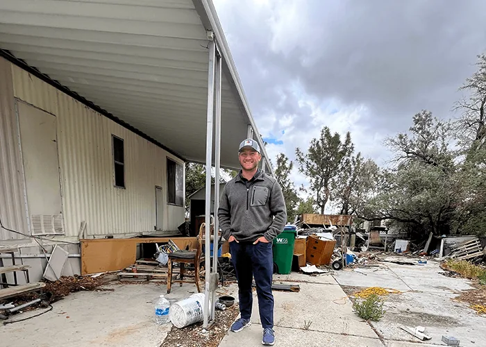Kyle Ridge outside a Northern Nevada property with construction debris and discarded items still in the yard